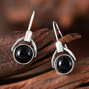 Compact round earrings with black cat's eye stones