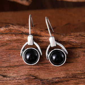 Compact round earrings with black cat's eye stones